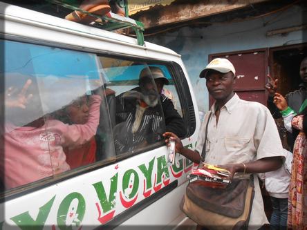 un vendeur devant un car
