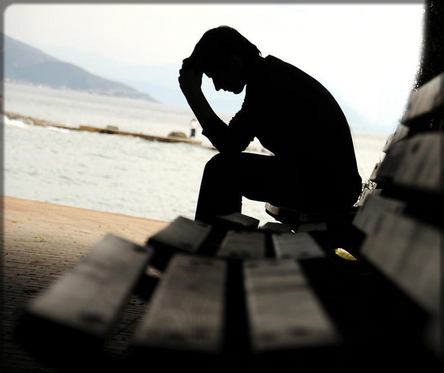 un homme triste sur un banc public