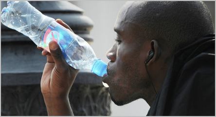 homme noir qui boit de l'eau minérale